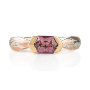 mokume gane whimsical engagement style ring with a unique hexagonal dusty rose sapphire in a partial bezel