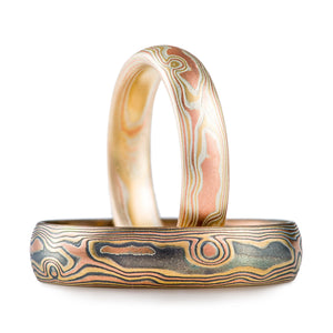 set of mokume gane bands in 3 metal combination - red gold yellow gold and silver, in a woodgrain pattern