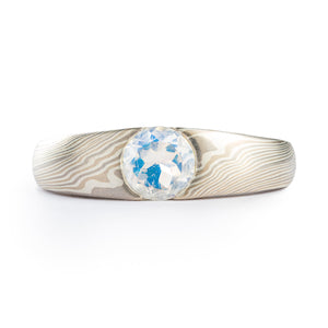 This classically beautiful Mokume Gane ring is shown in the Twist pattern and Smoke metal combination. It also features a lovely rainbow moonstone. The Smoke palette features White Gold, Palladium and Sterling Silver. 