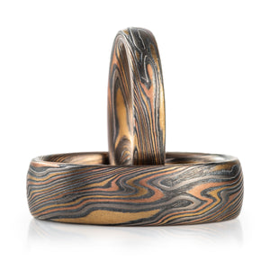 mokume gane matching ring set, made of red gold yellow gold palladium and oxidized silver in a twisted pattern