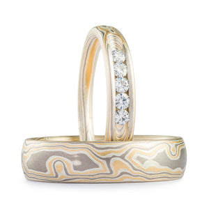 matching pair of mokume gane rings, one slightly narrower that also has channel set stones in it