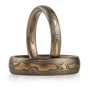 mokume gane matching ring set, made of yellow gold palladium and oxidized silver in a woodgrain pattern