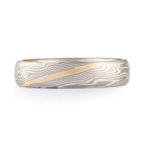 Mokume gane twist patterned ring with silver and palladium, and an added yellow gold layer running through the center of the band