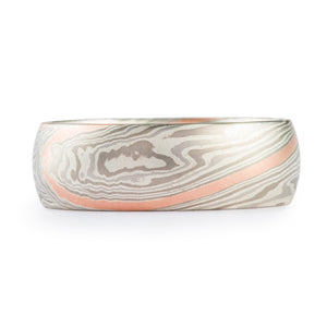 Silver mokume gane ring with an added red gold stratum layer, the other colors in the ring are all shades of gray, the pattern is a mokume gane twist 