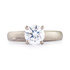 Twist pattern engagement style ring, with a round cut diamond set in prongs