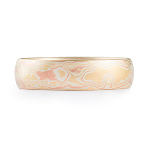 Woodgrain patterned mokume gane ring, plain band with a low dome profile and etched finish, and the ring is made of layers of red gold, yellow gold and silver.