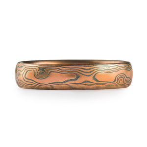 red gold and oxidized silver mokume gane band in a woodgrain pattern