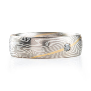 mokume gane band with a flush set salt and pepper diamond and an added yellow gold stratum layer