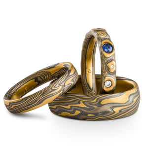 set of three mokume gane rings, wedding/engagement style set, textured mokume gane patterning, one ring has flush set stones
