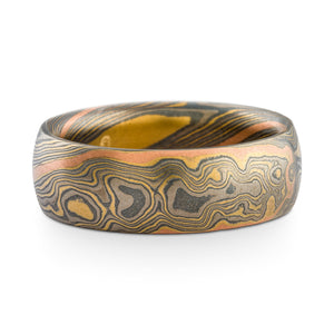 Mokume gane ring or wedding band made by arn krebs, twist pattern and flare palette (yellow gold, palladium and silver) with an added red gold stratum running through the pattern, etched and oxidized finish