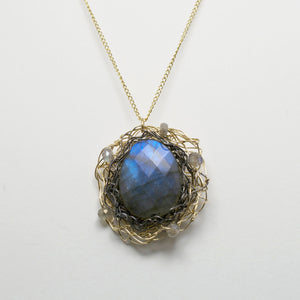 This spun pendant is made from hand woven layers of 14 kt gold filled wire and oxidized silver.  The centerpiece is a labradorite stone surrounded by smaller labradorite beads. Paired with a 1mm gold filled chain.  1" Diameter pendant