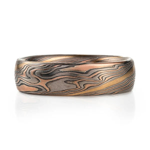 twisted mokume gane band patterned with an added gold stratum for contrast, main palette of the ring is red gold, palladium and oxidized silver