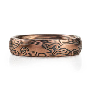 Red gold mokume gane ring with oxidized silver in a woodgrain pattern