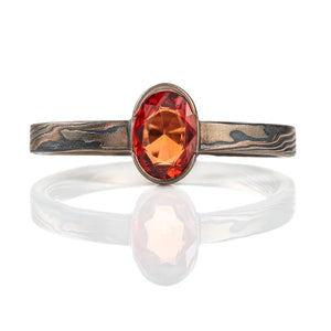 Mokume Gane engagement ring with orange sapphire oval cut stone bezel set unique artisan custom bespoke different Wedding ring white gold palladium sterling silver patterned artisan handmade fine jewelry topographical nature inspired mixed metal earthy organic style unique alternative metal stone