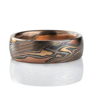 Mens mokume gane band made in twist pattern, with layers of red gold, yellow gold, palladium, and oxidized silver (black).