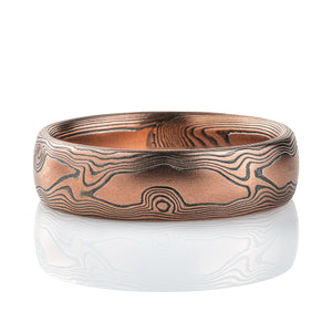 Red gold and oxidized silver mokume gane patterned ring designed to look like wood, slightly domed and of medium width.