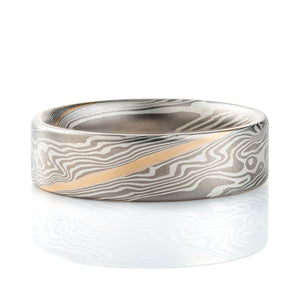 Wide flat profile mokume gane ring, patterned in twisting style, made with layers of palladium and silver for an overall gray palette, with one stripe of yellow gold.
