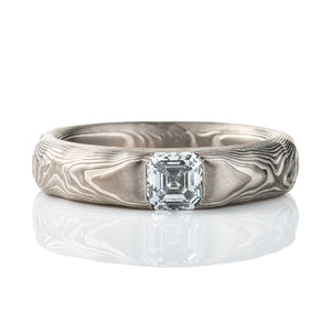 Textured mokume gane patterned ring, with three dimensional carving made to resemble rock. The ring is slightly thicker towards the top, to hold an asscher cut diamond that has been set flush into the ring.