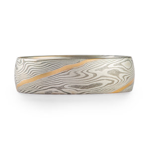 Mokume gane ring made in twist pattern, made of shibuichi and silver, with a single stripe of yellow gold.