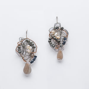 Earrings made of woven wire, interspersed with white and gray stones, with gray speckled teardrop stones hanging from the bottom edge.
