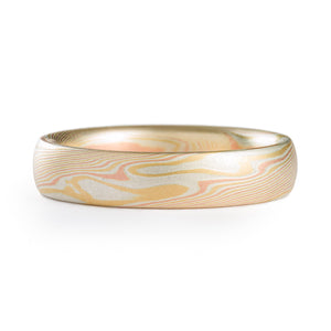 Mokume Gane twist patterned ring, made of layers of red and yellow golds and silver. The ring is 4mm wide and has a low dome profile and etched finish