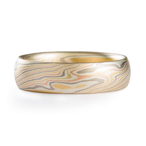 Mokume gane twist patterned ring made by Arn krebs, 6mm wide and low dome profile, made in our Firestorm metal combination. The ring has layers of red and yellow gold, palladium and sterling silver. The silver is most prominent in this ring, looking almost white next to the other colors as the ring has a non oxidized finish.