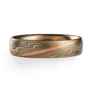 Mokume gane ring made by arn krebs, twist pattern with a red gold strip running diagonally across the ring, the rest of the ring is alternating layers of silver and palladium and yellow gold