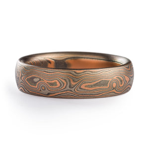 Mokume Gane ring made by arn krebs, patterning resembles woodgrain, made of alternating layers of red gold palladium and sterling silver, the silver has been darkened with oxidation