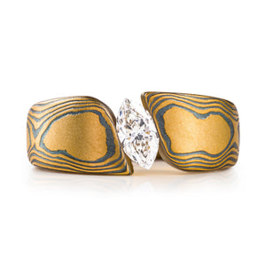 large and bold mokume gane tension set ring, featuring a beautiful marquise cut diamond set at an angle