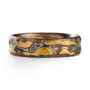 Mokume Gane ring made by Arn Krebs, layers of yellow gold, palladium and red gold alternate with oxidized silver, and the surface of the ring has been carved into in organic shapes to resemble topography