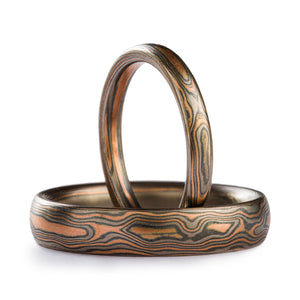 Matching ring set, mokume gane woodgrain patterned, both are very slim rings, upright ring is 2mm and laid down one is 4mm, metals in the rings are red gold silver and palladium