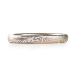 narrow dainty feeling mokume gane band, palladium and silver in twist pattern with a yellow gold stratum layer for accent