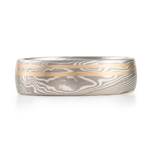 mokume gane ring, twist pattern (moves diagonally across the band, mixture of linear and organic pattern, ring has two yellow gold lines running horizontally across the band, the rest of the ring is silver and palladium