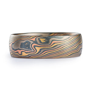 This rugged feeling Mokume Gane band is shown in the Twist pattern and the Firestorm metal combination with a low dome profile and an etched and oxidized finish.