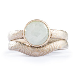 set of mokume gane rings, one engagement style with a rose cut sapphire, one band contoured to fit with stone setting