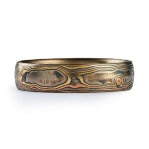 This earthy and organic feeling Mokume Gane band is shown in the Woodgrain pattern and the Firestorm metal combination, with a low dome profile, and an etched and oxidized finish. 