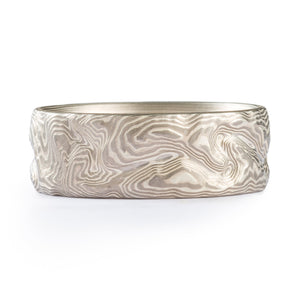 silver and grey swirling metal lines in Mokume Gane looks like topographical land formations 