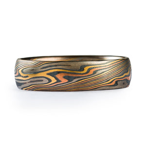 This beautiful Mokume Gane band is shown in the Twist pattern and the Firestorm metal combination with a low dome profile. Firestorm features the four-color 14k red gold, 14k yellow gold, Palladium and sterling silver palette.