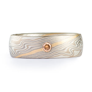 This beautiful and unique Mokume Gane ring is shown in the Twist pattern and the Smoke metal combination. It also features a flush set diamond, a low-dome profile, and an etched finish. 