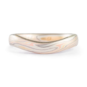 Mokume gane patterned ring, mixed metals with a smooth matte surface, contoured to fit with an engagement ring