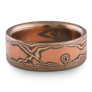 Wide men's mokume gane ring, flat profile for a modern look, made to look like warm toned wood grain, with red and yellow gold, and oxidized silver.