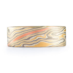 Flat profile ring, mokume gane style ring in a twist pattern with yellow gold, palladium and silver. There is also a red gold stripe layer running through the center of the ring