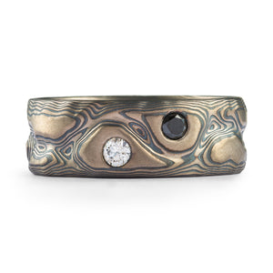 Guri Bori pattern mokume gane style ring, oxidized silver and palladium, with two round cut diamonds set into the ring, one black one white