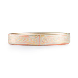 This elegant and hand crafted Mokume Gane band is shown in the Vortex pattern and the Fire metal combination with an etched finish and a flat profile. The Fire palette features 14k yellow gold, 14k red gold and sterling silver.