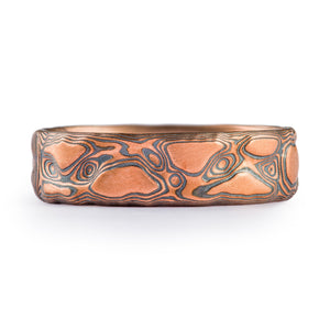 red gold islands and black oxidized layers and lines in this wide mens mokume ring 