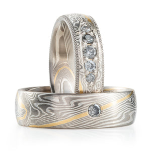 very elegant and classical wedding set, both rings made of palladium and silver with one stripe of yellow gold, both have salt and pepper diamonds, one has added milgrain rails 