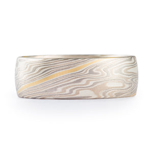 classic feeling wide mokume gane band in smoke palette (silver, palladium and white gold) with a yellow gold stratum layer as accent