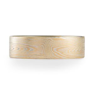 mokume gane specialty subtle wedding band in a linear style pattern and yellow gold and silver