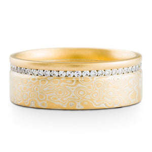 Mokume gane ring or wedding ring by arn krebs, eternity setting, spark palette and droplet pattern, added yellow gold rail on top, small moissanites all the way around the band, yellow gold and sterling silver