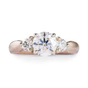 elegant and dazzling mokume gane ring, engagement style with three stones set into prongs. All diamonds, one larger in the center and flanked by two smaller ones.